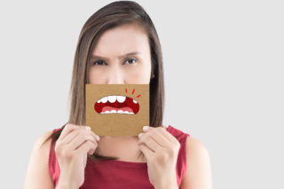 Lady holding cartoon of missing tooth